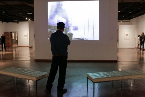 A visitor to the Boom to Bust exhibit watches a showing of Manhatta, a film by Charles Sheeler and Paul Strand, Oct. 20.