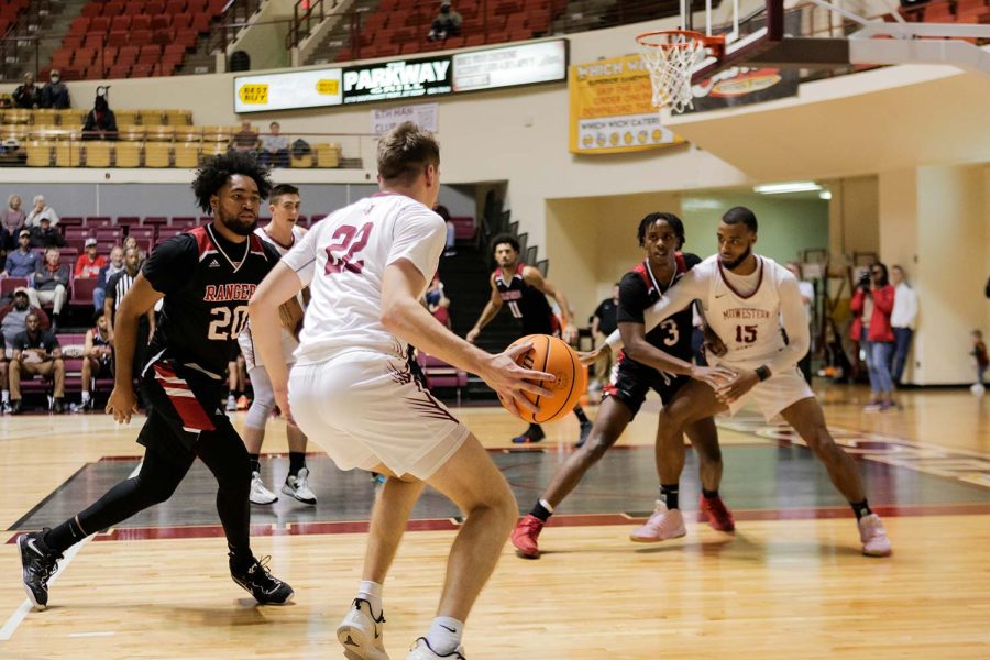 General business senior John Weger searches for an open teammate to pass to while avoiding Northwestern Oklahoma players, Nov. 17.