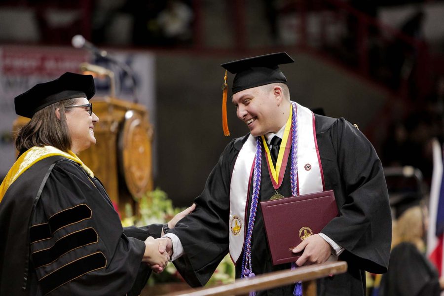 After receiving his degree, Bachelor of Science in Nursing graduate Timothy Germain shakes the hand of College of Science, Mathematics & Engineering dean Margaret Brown Marsden, Dec. 10. Germain graduated summa cum laude, with a 4.0 GPA.