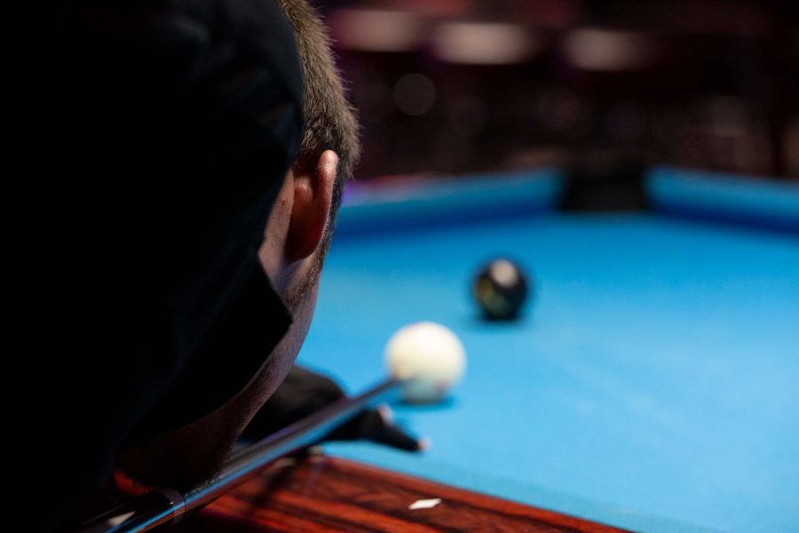 Pool player Michael French lines up a finishing shot on the 8 ball, Nov. 30. French competes in tournaments both at the national and local level, including a charity tournament called Addy’s Avengers.