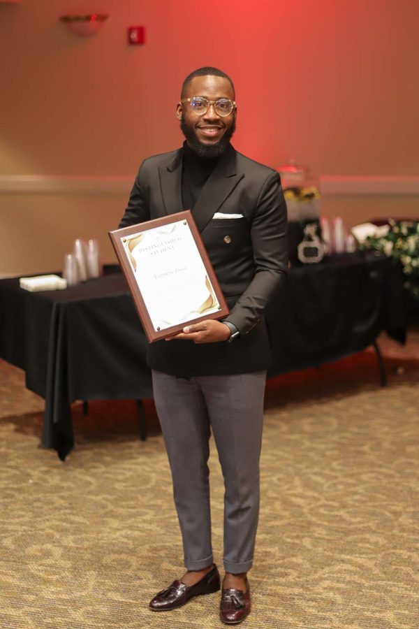 Global studies senior Lumiere Bisisi holds his distinguished student award, which he received during the gala, Feb. 17.