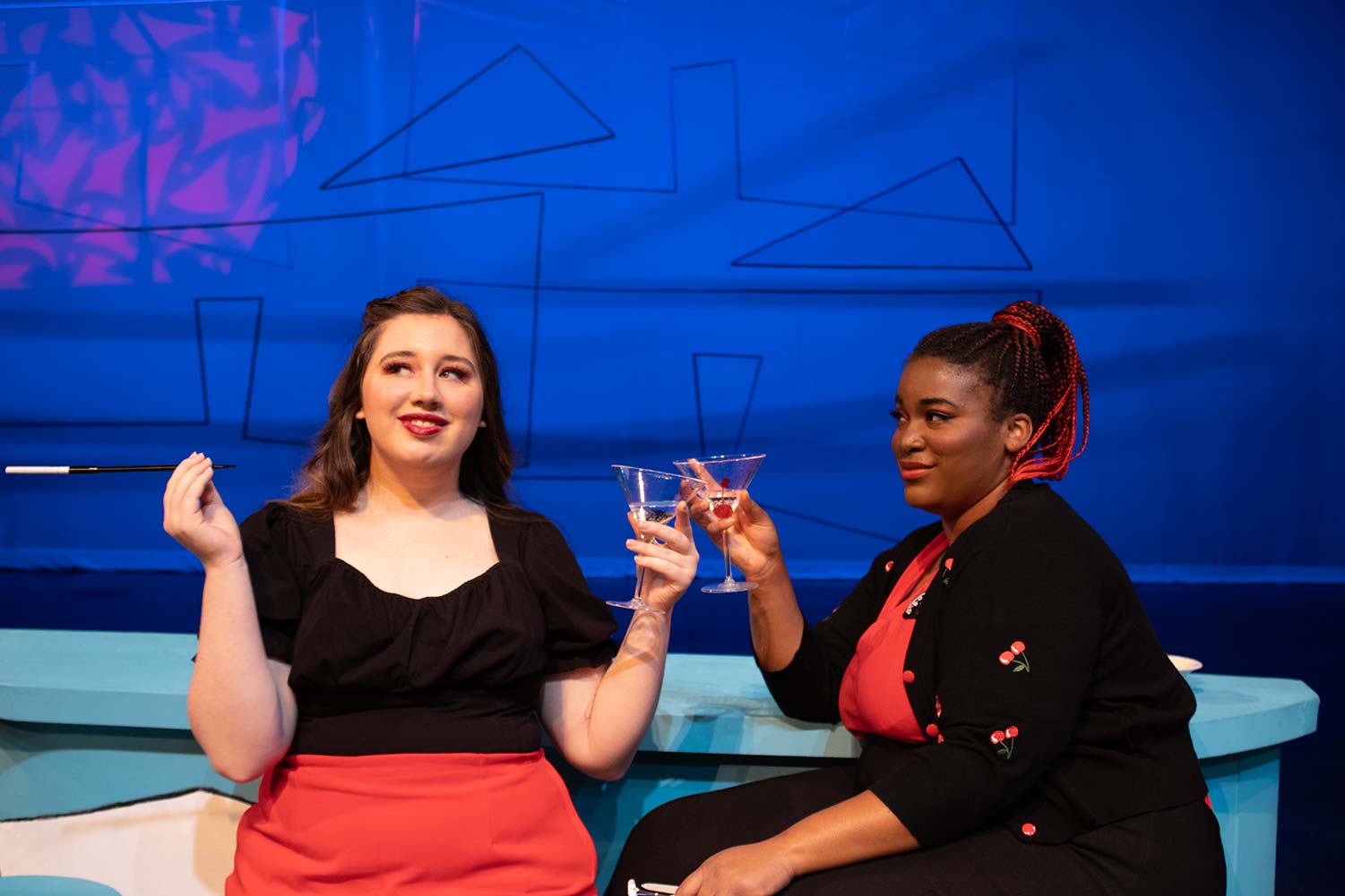 Gabbi Enriquez as Nym and Nae Nae Hughes as Pistol clink glasses at the bar, April 27. They will perform these roles alongside their co-actors this weekend from Friday to Sunday.