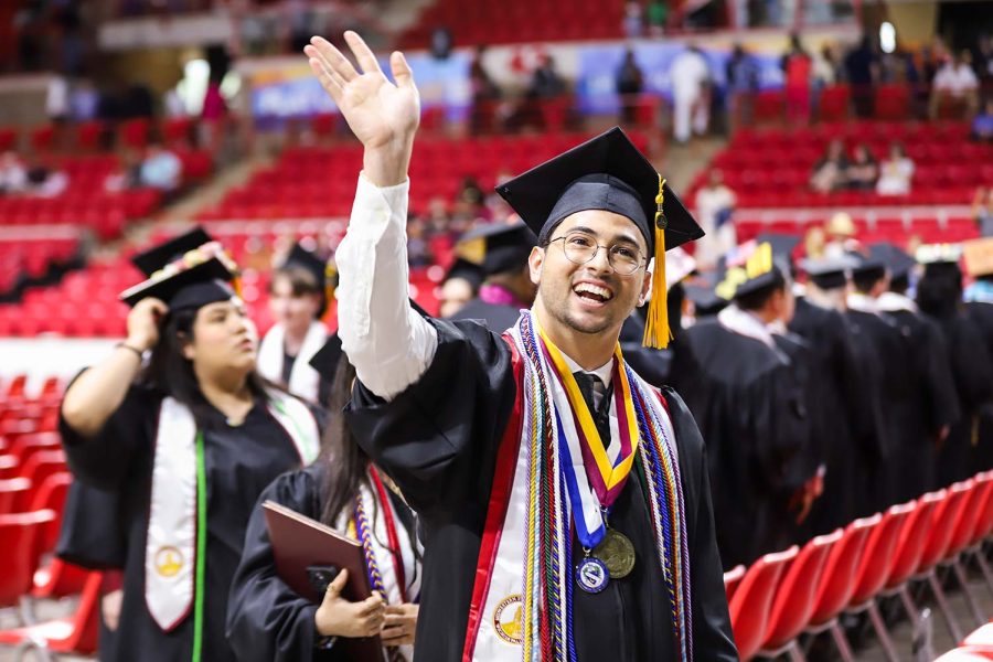 Pre-medical graduate Andrea Repici waves to his famly as he proceeds out of Kay Yeager after graduating, May 13.