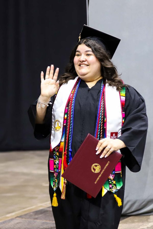Marketing graduate Esmeralda Carlos walks off the stage with diploma in hand, May 13.