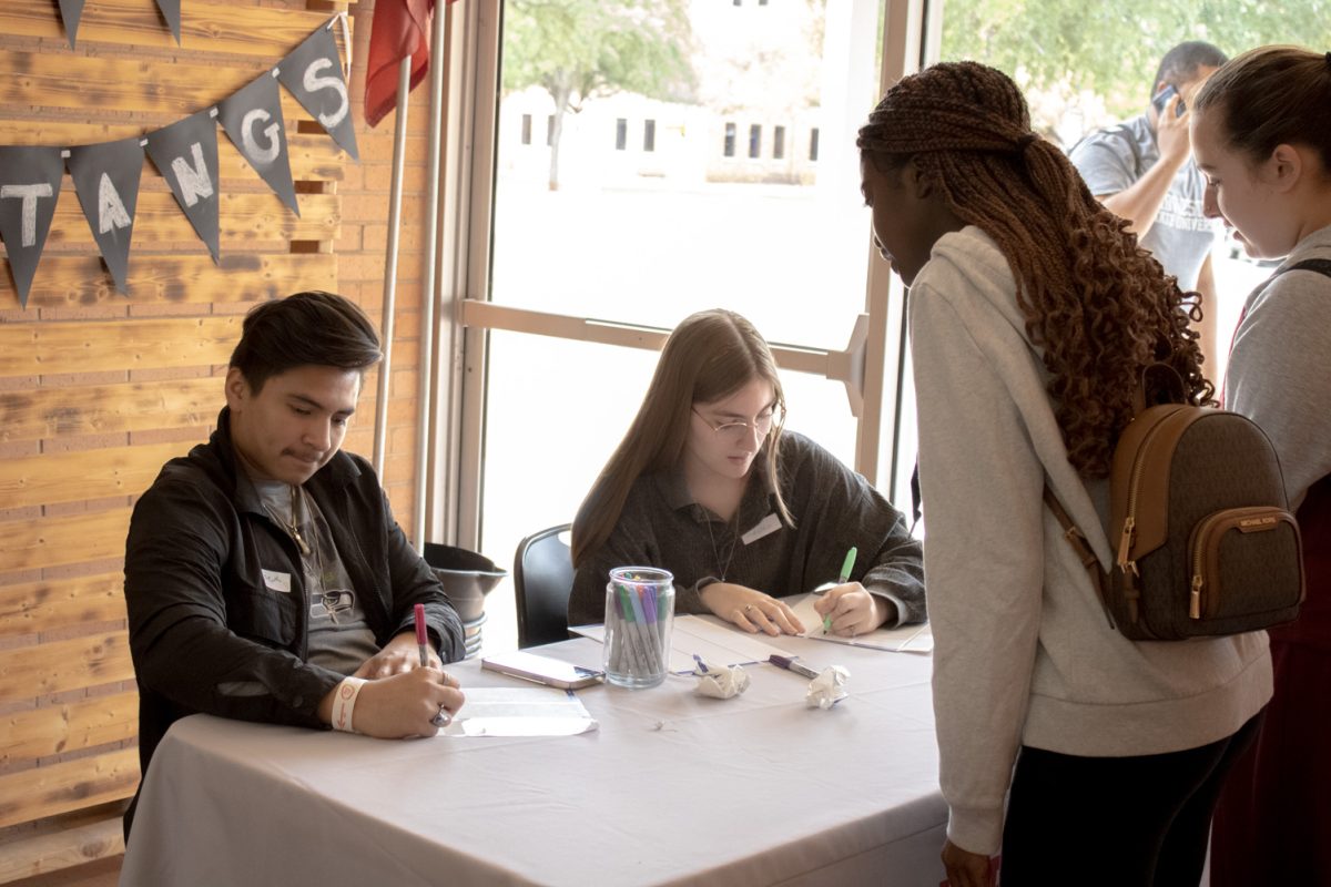 Criminal justice junior Joseph Mendez and education sophomore Natasha Moore write down students names on name tags as they walk in the BSM., Sep. 13.