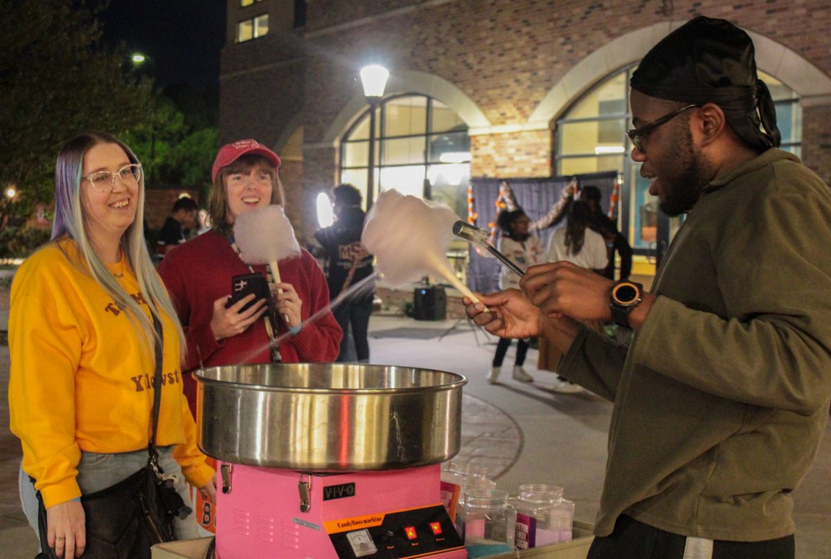 Marcus Morris, mass communication junior, makes cotton candy for Arthur Boatman, Assistant to the Registrar Office, and Brianna Satterfield, Museum, Collections Manager, Nov. 11.