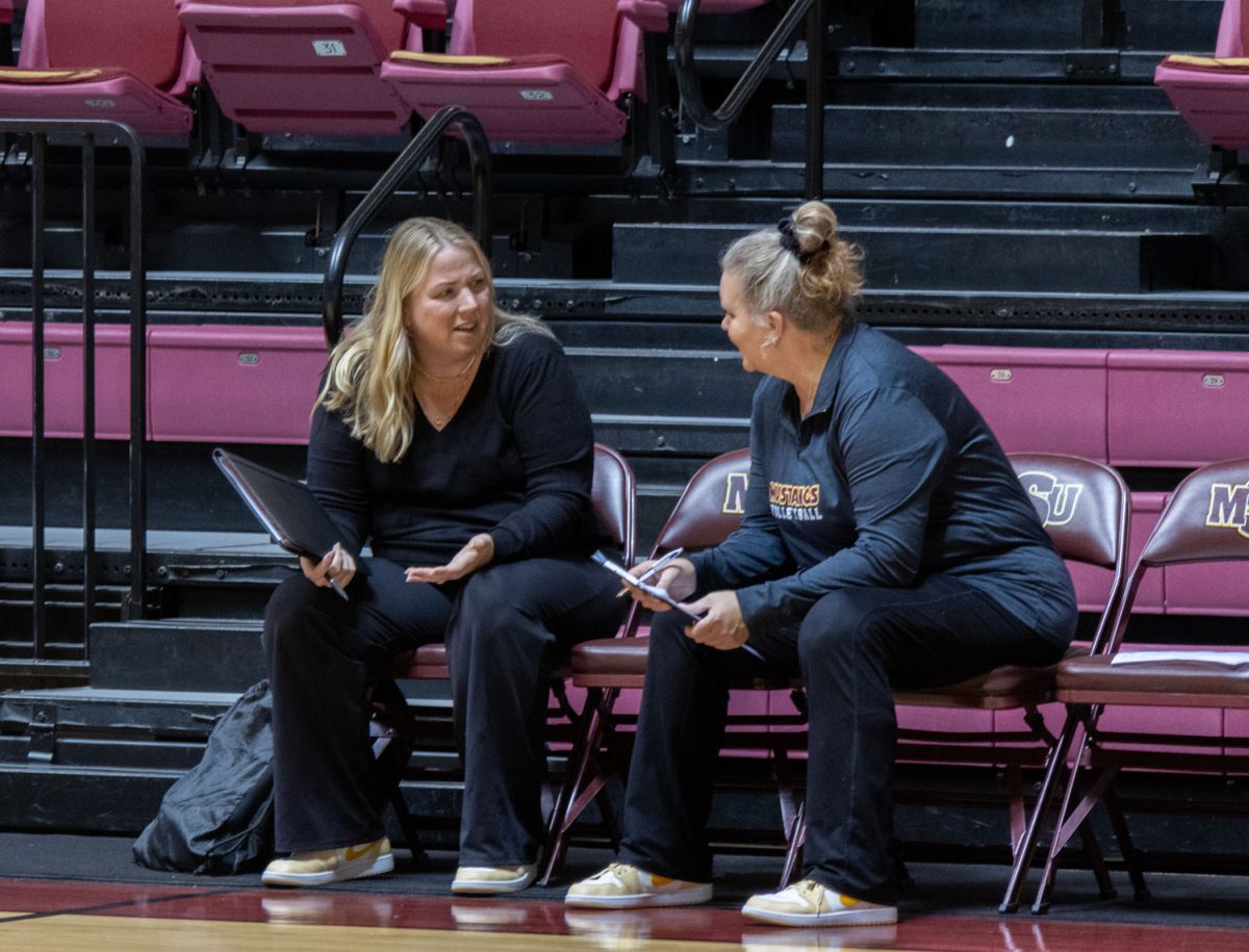 Head coach Stephanie Radecki (left)  strategizes with assistant coach Jennifer McCall (right) inbetween sets one and two, Nov. 6.