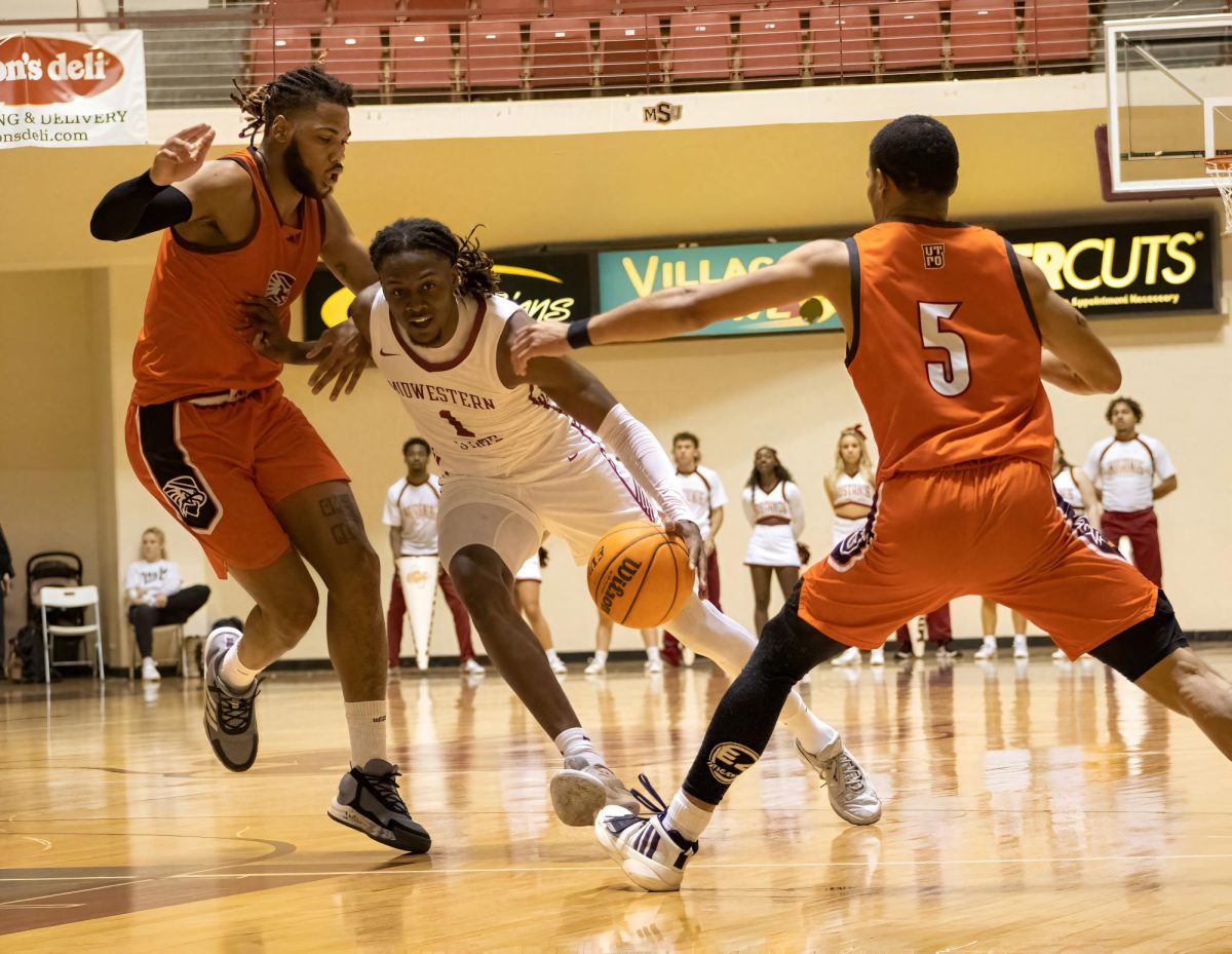 Reggie Hill (1) pushes past two Angelo players, Jan. 20.