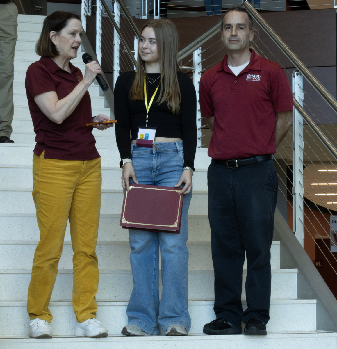 President Stacia Haynie and Honors Director Steve Garrison present incoming nursing freshman Nicole Tatsch with the Presidential Scholarship during Mustangs Rally, March 1.